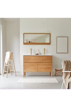 a bathroom with white walls and wooden furniture