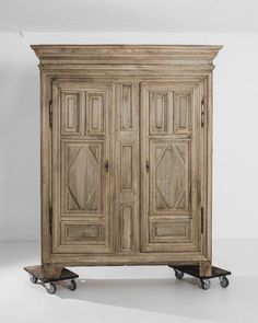 an old wooden cabinet with wheels on the bottom and doors in the middle, against a white background