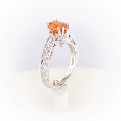 Gorgeous orange Spessartite Garnet set in a delicate modern regal setting. This ring features a hint of vintage and a lot of color. Oval 6x4mm Fancy Spessartite Garnet totals 1.48ct Setting totals 1/8ct diamonds 14k White Gold, ornate filigree detailing Size 7 - Free sizing available Please contact us to learn more or schedule a virtual appointment! Garnet And Diamond Ring, Spessartite Garnet, Garnet, To Learn, Diamond Ring, Diamonds, White Gold, Size 7, Engagement Rings