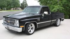 a black pickup truck parked in a driveway