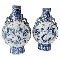 two blue and white vases sitting next to each other