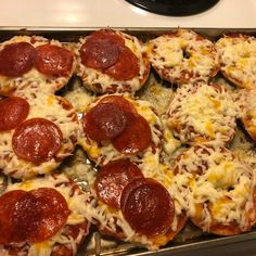 pepperoni and cheese mini pizzas on a baking sheet ready to go into the oven