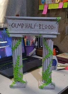 a laptop computer sitting on top of a desk next to a sign that says karmi half blood