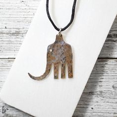 an elephant shaped pendant on a black cord