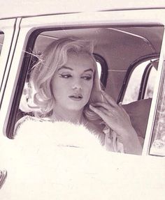 a black and white photo of a woman in a car