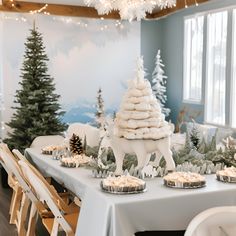 a table topped with cupcakes covered in frosting next to a christmas tree