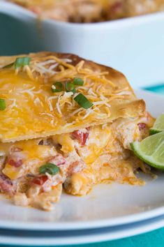 a white plate topped with two quesadillas covered in cheese and toppings