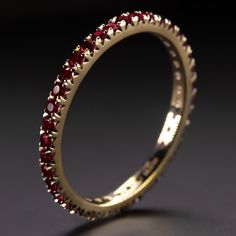 Why we love it:This ruby band has a classic design with rich red rubies continuing all the way around the band! It is a great choice for a wedding band or a stand alone piece.Highlights:- 0.70 carat of natural rubies- Full eternity design- Solid 14k yellow gold settingDimensions:The ring measures 1.9mm across (north south) and 2.0mm from finger to topSizing:As an eternity ring, this can’t be easily resized. It is only available in size 6.Additional Notes:This is part of a larger collection of na Ruby Ring Designs Gold, Stackable Ruby Eternity Band For Weddings, Classic Ruby Eternity Band For Formal Occasions, Yellow Gold Ruby Halo Ring For Wedding, Luxury Stackable Ruby Ring For Wedding, Yellow Gold Ruby Birthstone Ring With Round Band, Gold Ruby Ring For Wedding, Yellow Gold Ruby Birthstone Ring, Stackable Yellow Gold Ruby Ring For Wedding