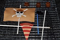 there is a pirate flag made out of paper on the grill with marshmallows