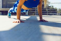 a woman is doing push ups on her hands and knees while wearing blue sportswear