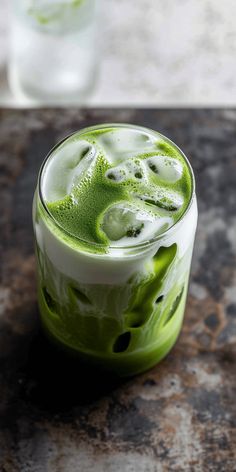 a drink with green liquid in it sitting on a table