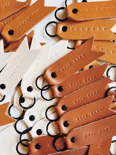 leather key fobs are laid out on a table with tags attached to them