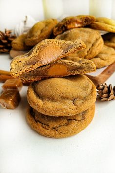 several cookies stacked on top of each other next to some pine cones and cinnamon sticks