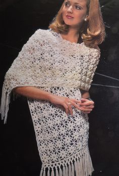 a woman is wearing a white crocheted shawl