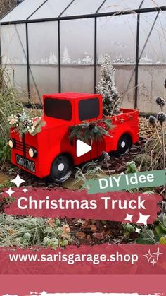 a red truck with christmas decorations on the front and side, sitting in a garden