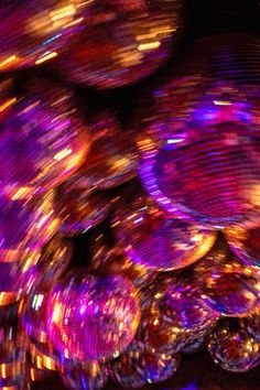 an array of disco balls are lit up in purple and orange colors with lights on them