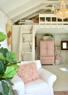 a white couch sitting under a pink chandelier