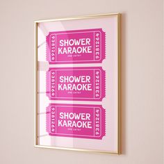 two pink tickets are hanging on the wall next to a mirror that says shower karaoke