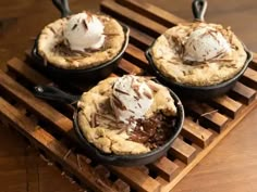 three pies with ice cream and chocolate on a wooden tray, ready to be eaten