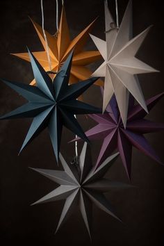 four different colored paper stars hanging from strings