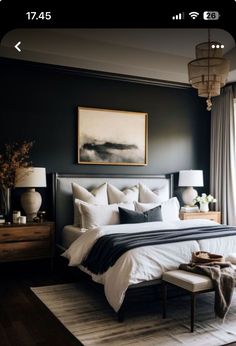 a bedroom with black walls and white bedding