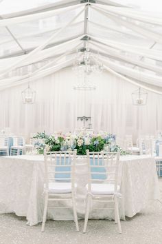 the tables are set with white linens and blue chairs for an elegant wedding reception