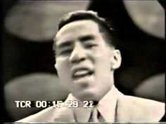 an old black and white photo of a man in a suit talking into a microphone