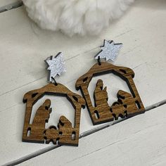 two wooden nativity scene earrings with stars on the top and one in the middle