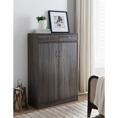 a wooden cabinet sitting in front of a window next to a rug on the floor