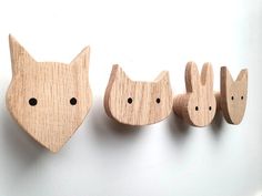 three wooden animals are lined up on the wall