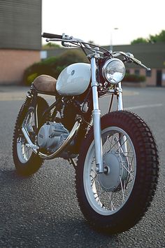 a white motorcycle parked on top of a parking lot