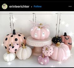 some pink pumpkins are sitting on top of a white cake stand with black polka dots