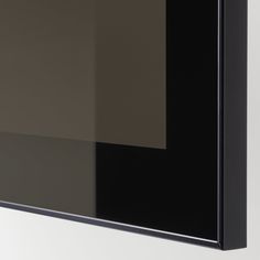 a black and grey wall hanging on the side of a white wall in an empty room