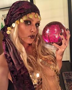 a woman dressed in costume holding a disco ball