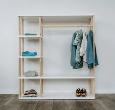 a white shelf with clothes and shoes on it