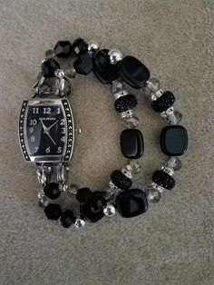 This elegant black watch band has black rectangular beads, smokey crystals, and sparkly black rondelles. A hint of silver is added with small silver colored beads. The watch face is a curved rectangular black face with silver numbers and hands. Beads may vary slightly according to availability.  Ladies watch band sizing: Simply measure your wrist snuggly with a string or ribbon.  Order your size (i.e. small, medium, large) according to your measurement. Minimalist Watch Women, Silver Bracelet Watch, Beaded Watches, Silver Watches Women, Rose Gold Watches Women, Green Watch, Rhinestone Watches, Bracelet Watches Women, Silver Numbers