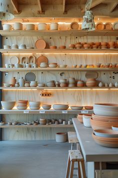 the shelves are filled with many different types of plates and bowls on them, all stacked up against each other