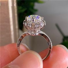 a person holding a diamond ring in their hand with the center stone on it's side