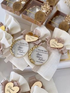 personalized wedding gifts for guests are displayed in boxes with bows and tags on them