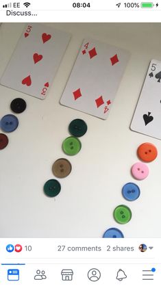 two playing cards with different colored buttons on them and one showing the same amount of each card