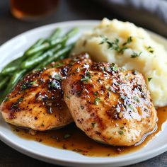 chicken, mashed potatoes and green beans on a white plate with gravy