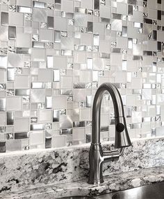 a kitchen sink sitting under a faucet in front of a tiled backsplash