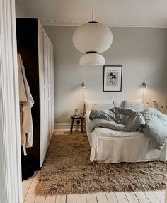 a bed sitting in a bedroom on top of a wooden floor next to a doorway