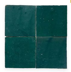 four squares of dark green marble with white speckles on the top and bottom