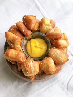 a plate filled with dough and pretzel bites next to a jar of mustard