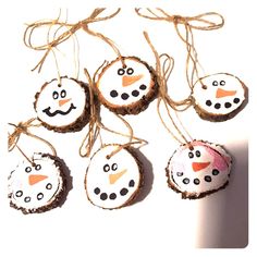 four snowman ornaments are hanging from twine