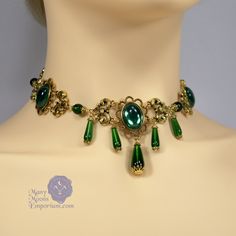 "Noble elegance is conveyed in the richly textured Marquise Xanthe necklace. Smooth glass teardrops capped in filigree dangle sumptuously at the front of this link style necklace while emerald green gems and antique gold swirled links envelop the neck. This necklace closes with a hook clasp and the length is adjustable from 16\" to 20\" to be worn at the length of your choice. Coordinating earrings are also available to complete the set. Also available in black onyx, sapphire blue, ruby red, and Formal Drop Emerald Necklace, Drop Emerald Necklaces For Formal Occasions, Emerald Drop Necklace For Formal Occasions, Green Drop Jewelry For Jewelry Making, Green Emerald Bridal Necklace Gift, Emerald Teardrop Pendant Necklace For Weddings, Elegant Green Teardrop Necklace, Victorian Gold Emerald Jewelry, Emerald Drop Jewelry With 17 Jewels