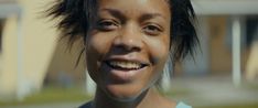 a close up of a person with a smile on their face and hair in the wind