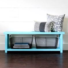 a blue bench with two baskets on it and a pillow sitting on top of it