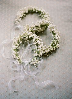 two wreaths made out of baby's breath flowers on top of a bed